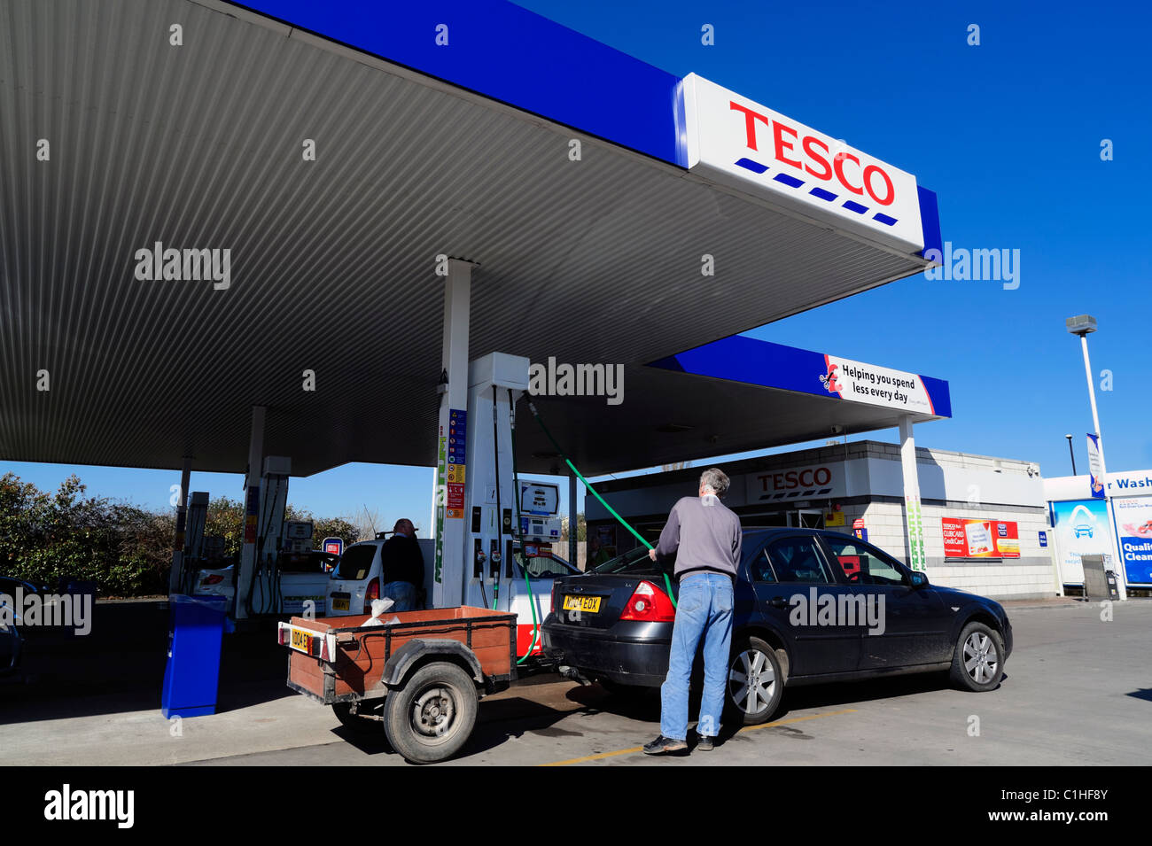 Tesco la benzina al supermercato in Gloucester, Regno Unito. Esterno del supermercato britannico stazione di riempimento benzina cielo blu in una giornata di sole. Foto Stock