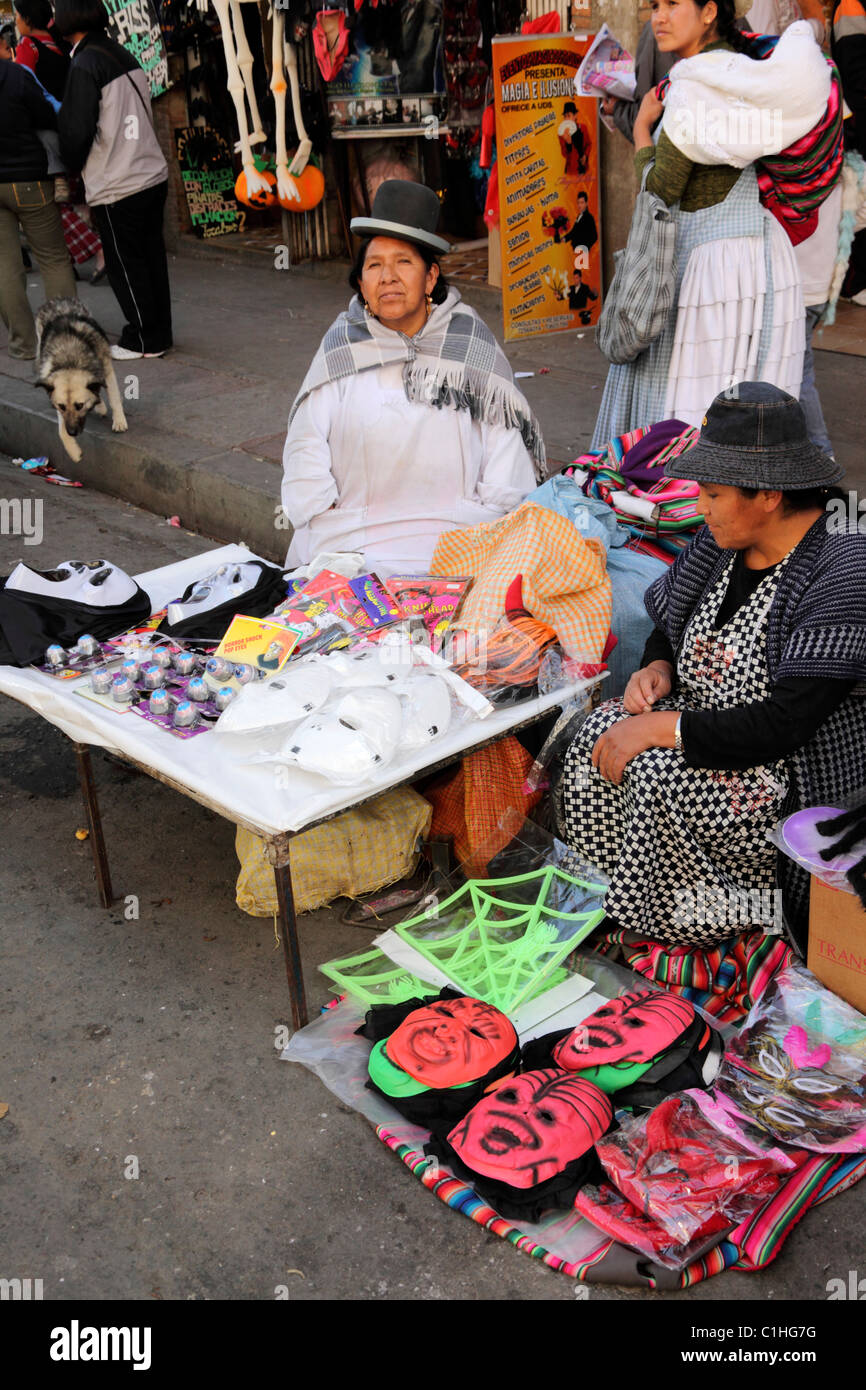 Aymara donne che vendono maschere in gomma e plastica al mercato di strada per Halloween, la Paz , Bolivia Foto Stock