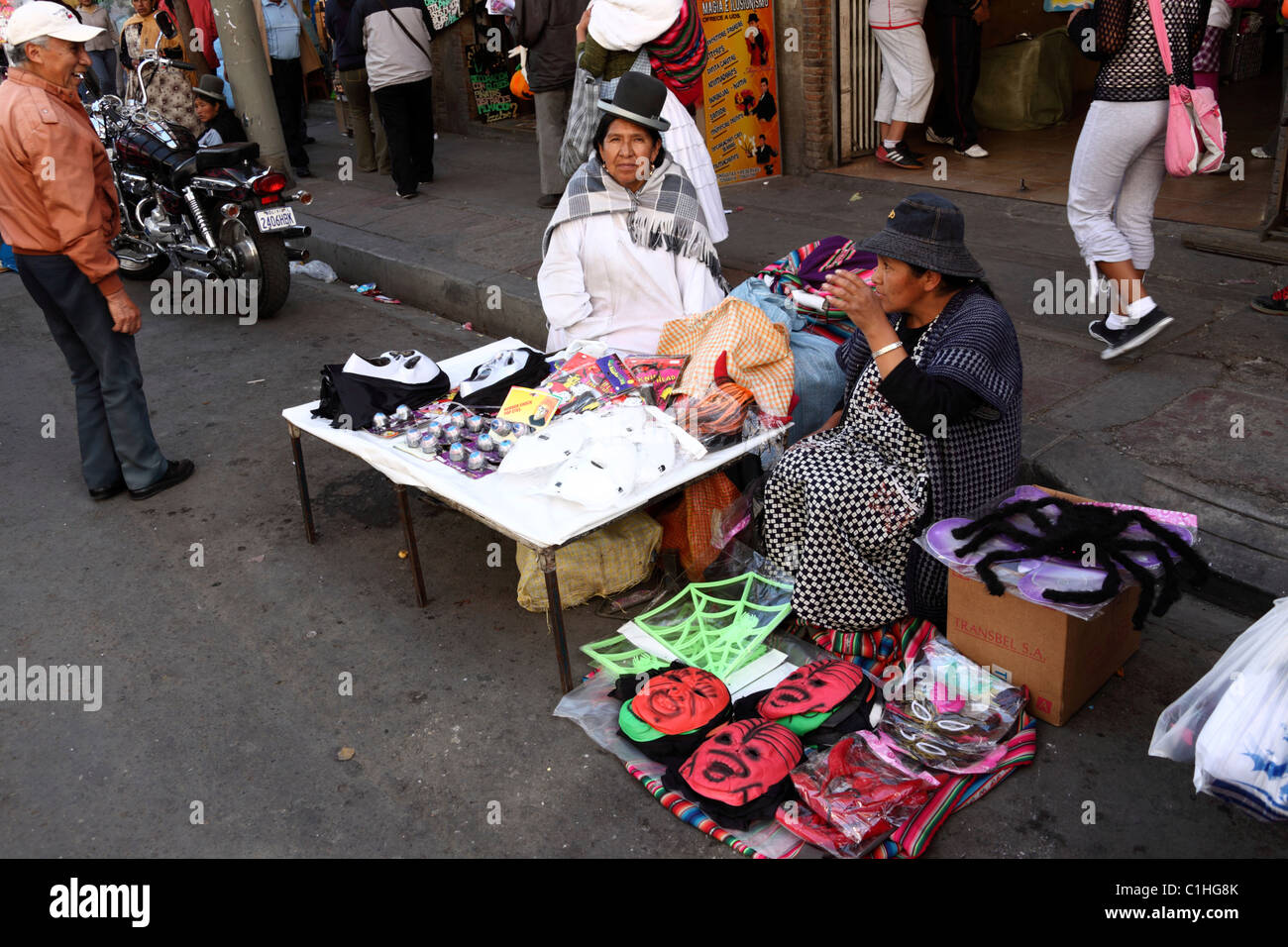 Aymara donne che vendono maschere in gomma e plastica al mercato di strada per Halloween, la Paz , Bolivia Foto Stock