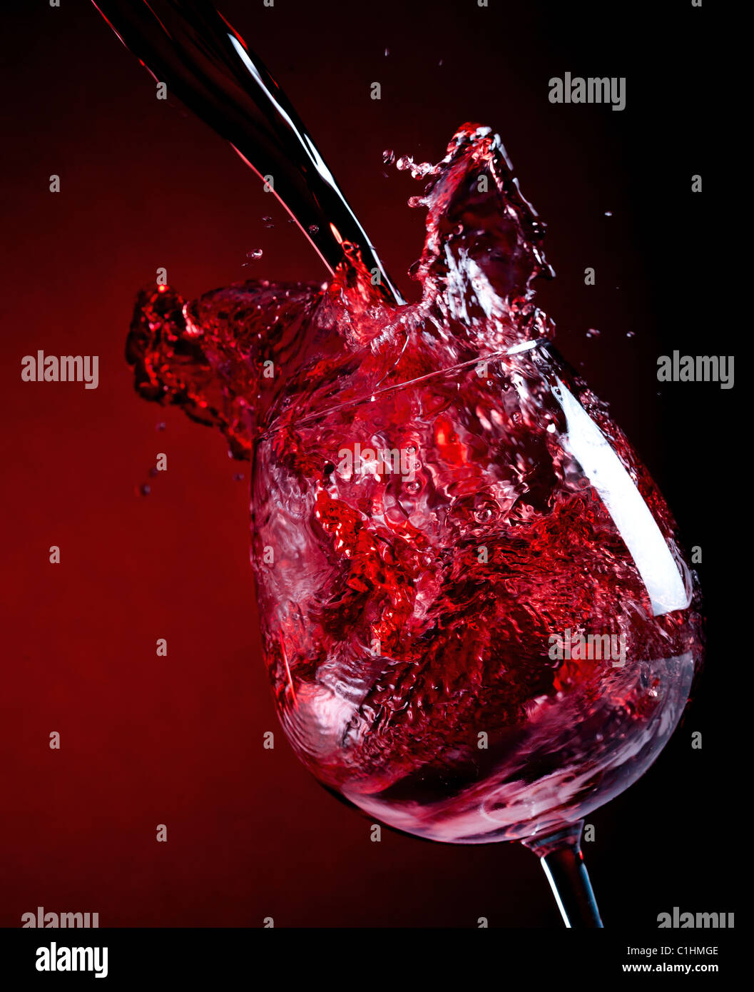 Vino rosso versando in giù in un bicchiere da vino Foto Stock