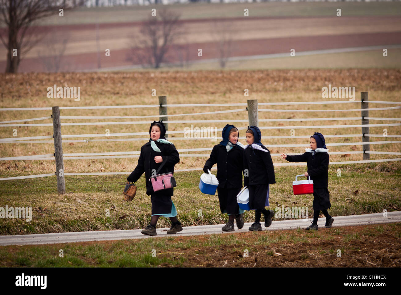 Ragazze Amish a casa a piedi dalla scuola in Gordonville, PA. Foto Stock