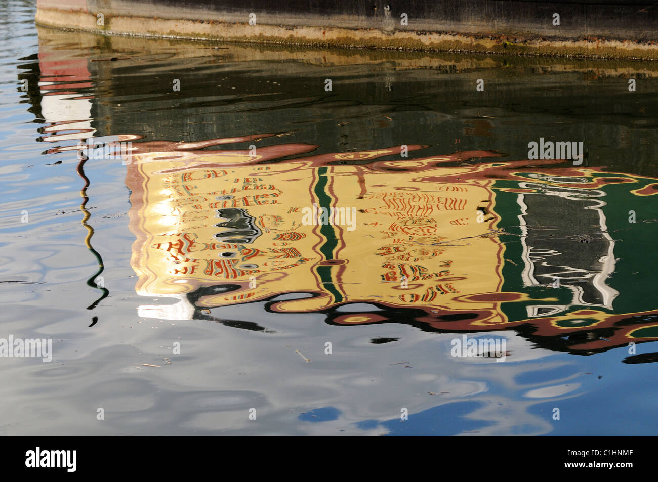 La riflessione in Ashby Canal di una chiatta illuminata dalla luce della sera Foto Stock