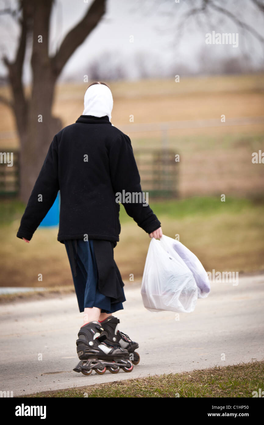 Ragazza Amish roller blade a casa da scuola in Gordonville, PA. Foto Stock