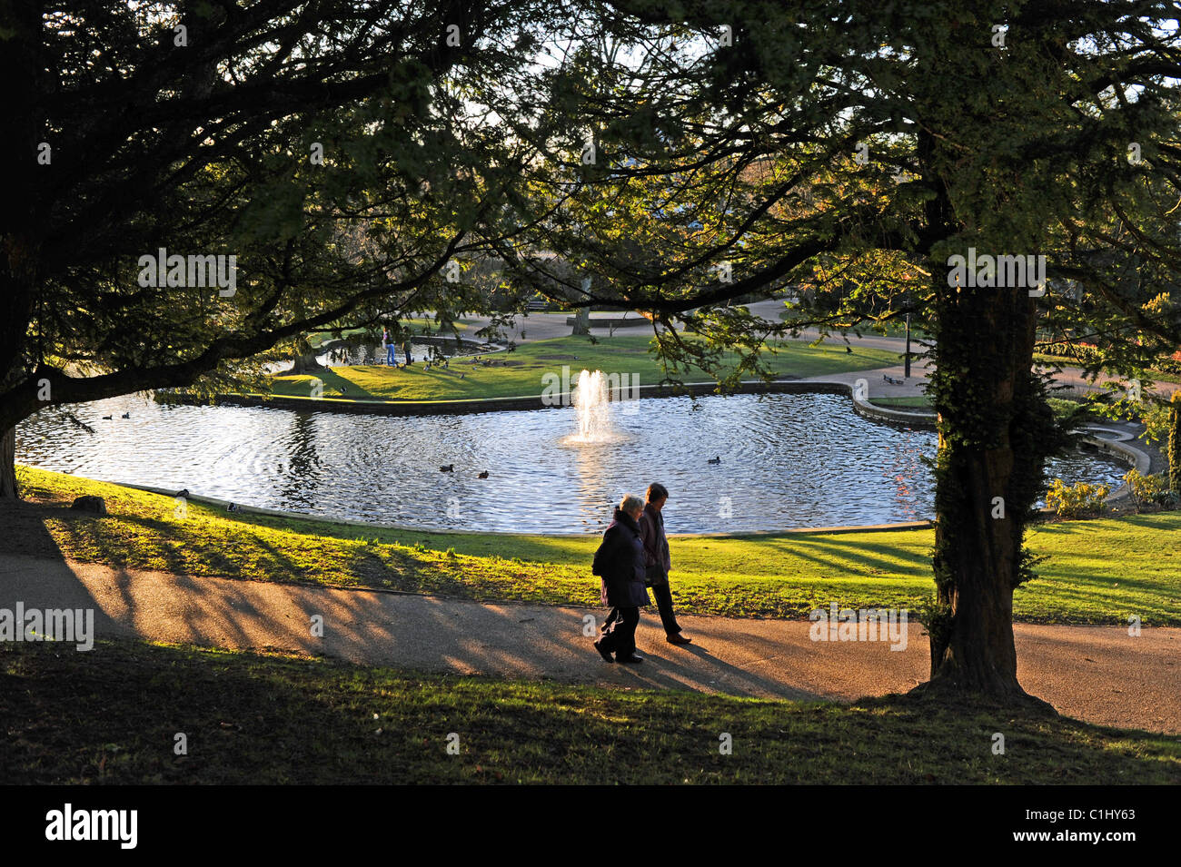 Giovane oltrepassando la fontana in Pavilion Gardens nel Derbyshire Peak District città di Buxton UK Foto Stock