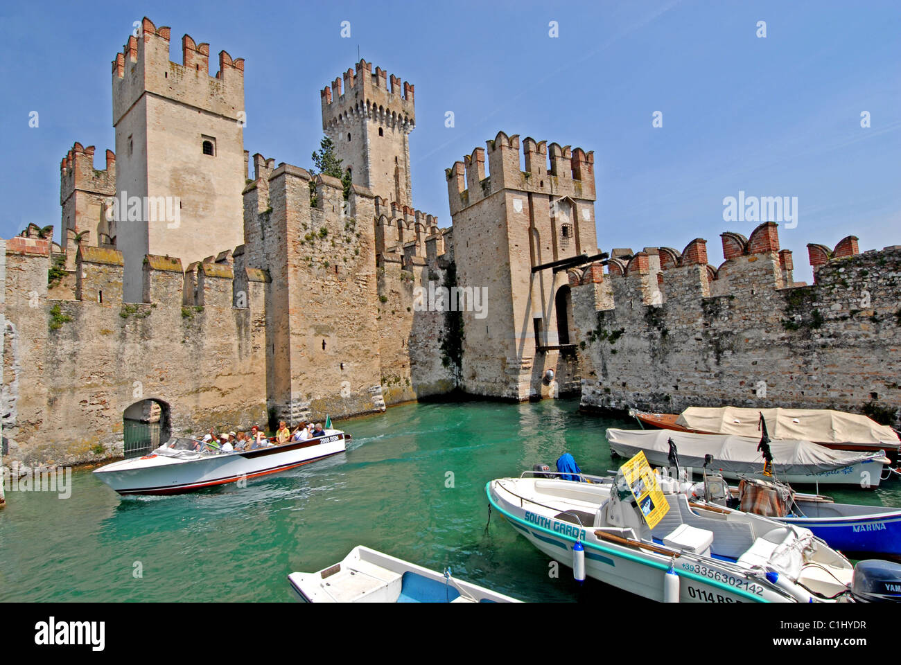 Tourboats intorno al castello scaligero, Sirmione sul Lago di Garda, Italia Foto Stock