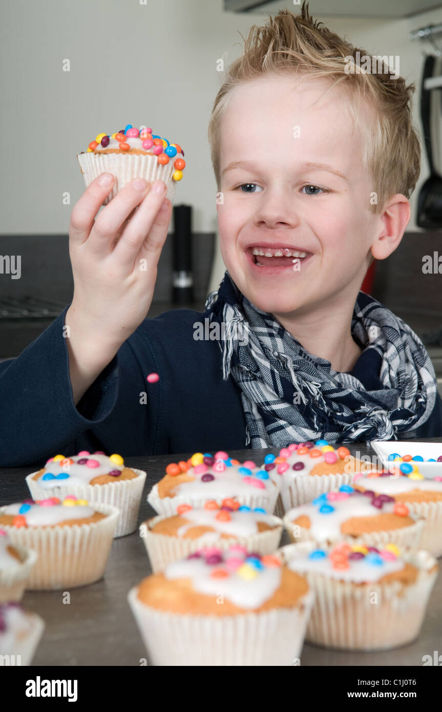 Bambino è decorare il proprio tortini al forno Foto Stock