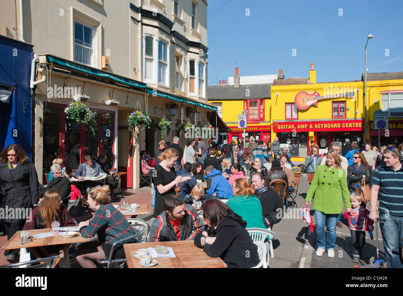 La gente fuori nei primi sole primaverile, il sabato a pranzo in Gardner Street, nel Nord area di corsie di Brighton, Inghilterra. Foto Stock