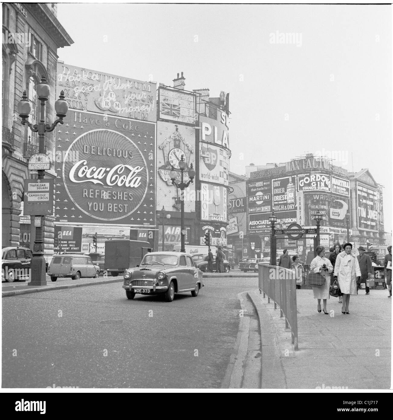 1960s, un'auto sale su Regent Street, da Piccadilly Circus, con i suoi famosi cartelloni pubblicitari al neon, Londra, Inghilterra, Regno Unito. Foto Stock
