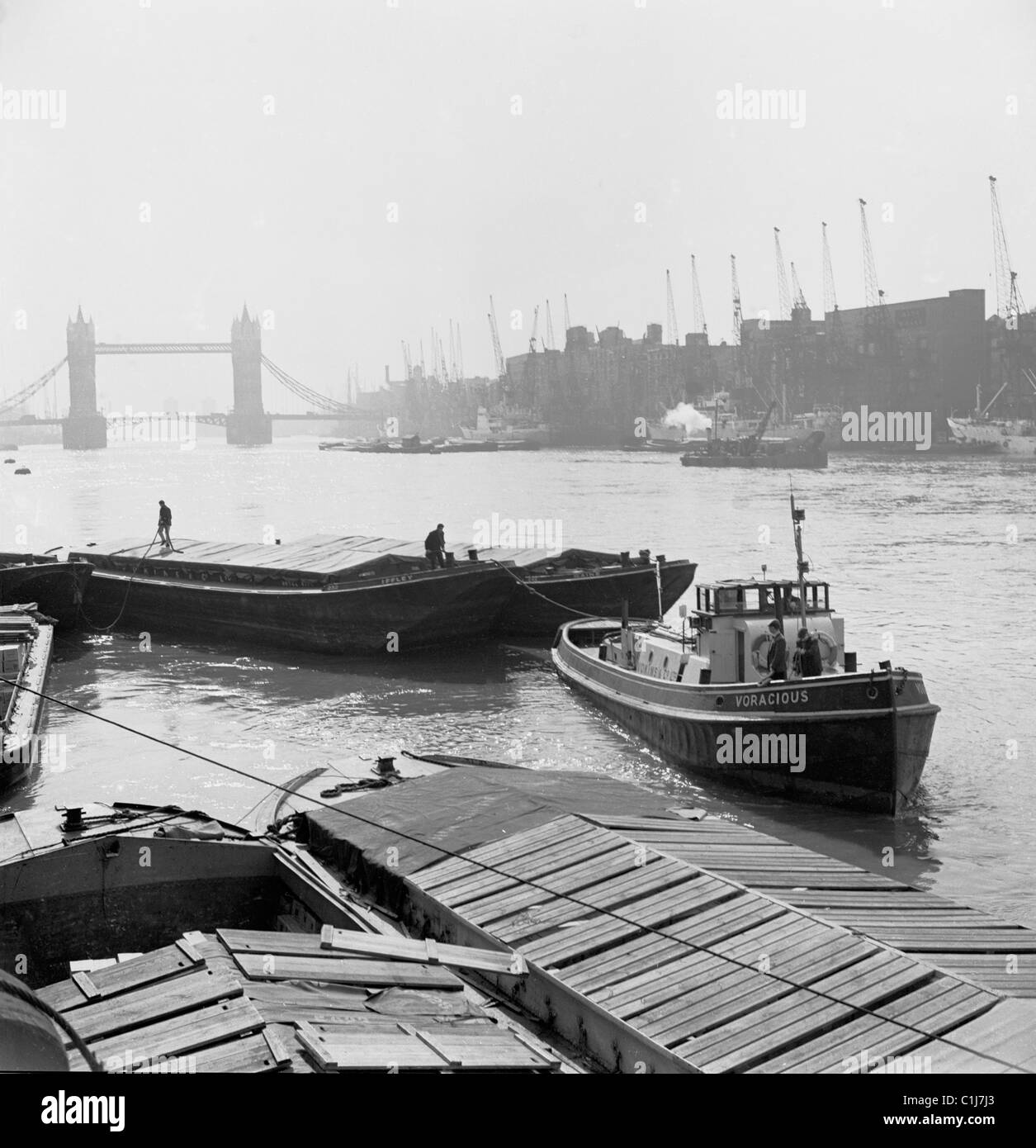 Londra, 1950s. Fotografia di J Allan contanti di una chiatta di lavoro sul Fiume Tamigi, con il Tower Bridge in distanza. Foto Stock
