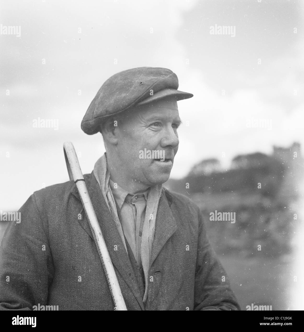 1950, fotografia storica di un pastore che indossa un berretto di stoffa e con un truffatore sulla spalla, un luogo comune nella campagna inglese in quest'epoca. Foto Stock