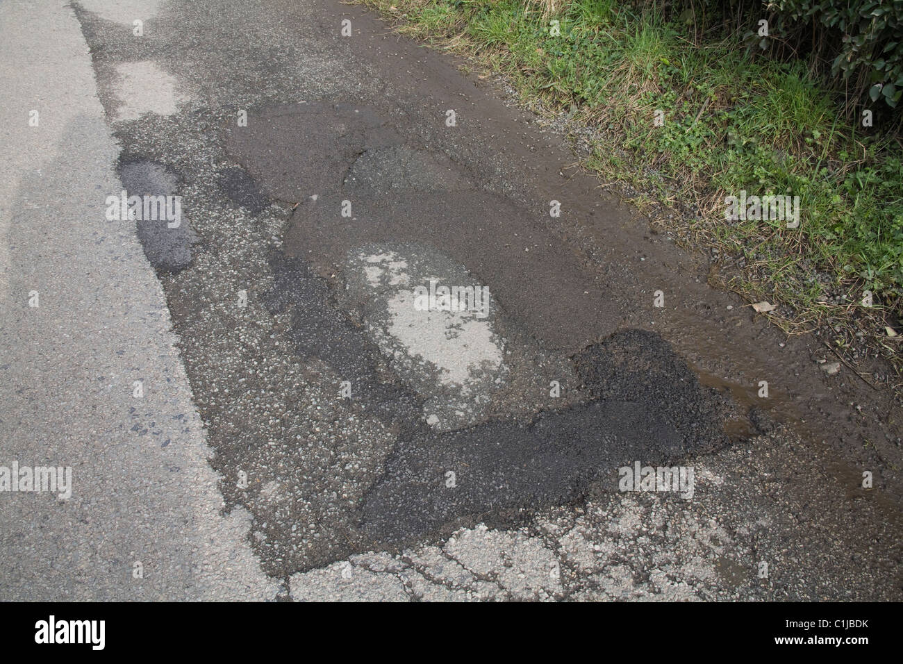 Regno Unito riparato precedentemente superficie stradale iniziando a rompere danneggiati dal gelo Foto Stock