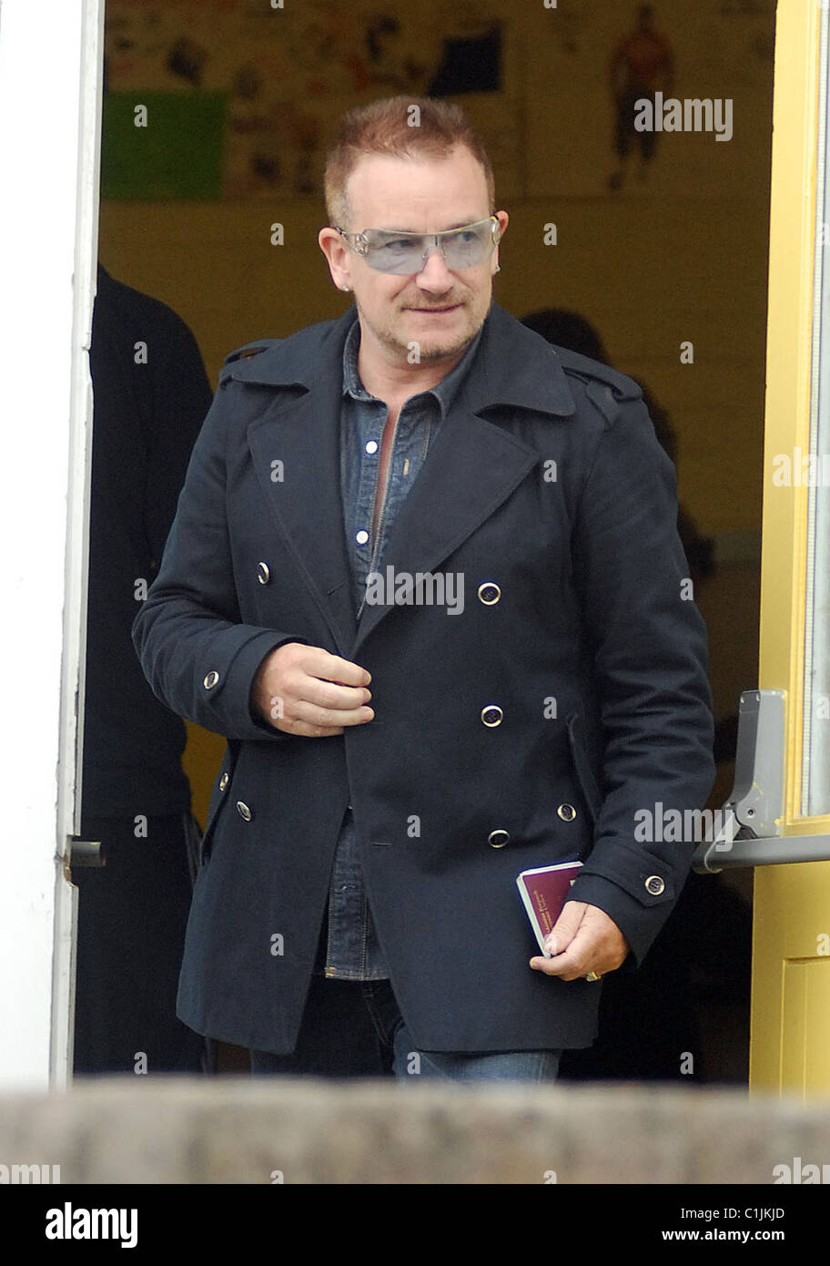 Bono lasciando il suo locale stazione di polling portando la sua scheda di voto e il passaporto per il voto in occasione delle elezioni locali ed europee. Foto Stock