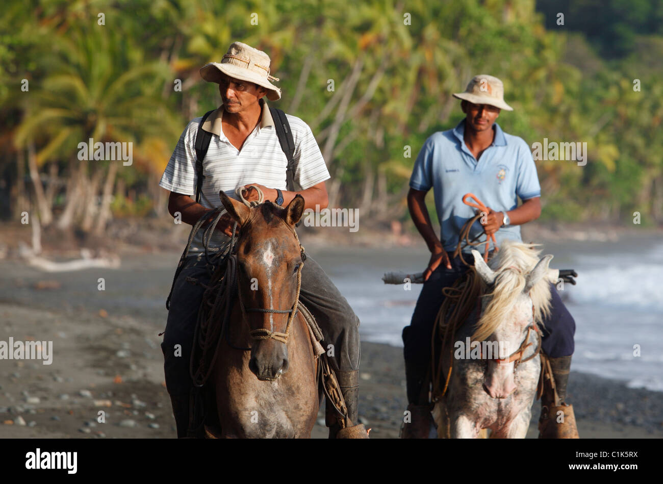 Costa Rican uomini andare a cavallo sulla spiaggia di Punta del Banco, Costa Rica Foto Stock