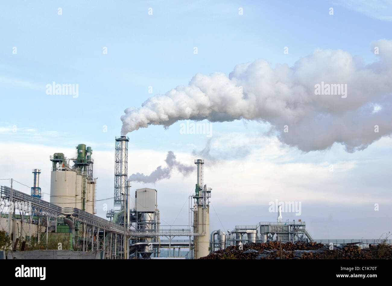Il fumo della fabbrica, inquinando l'aria con il cielo nuvoloso Foto Stock