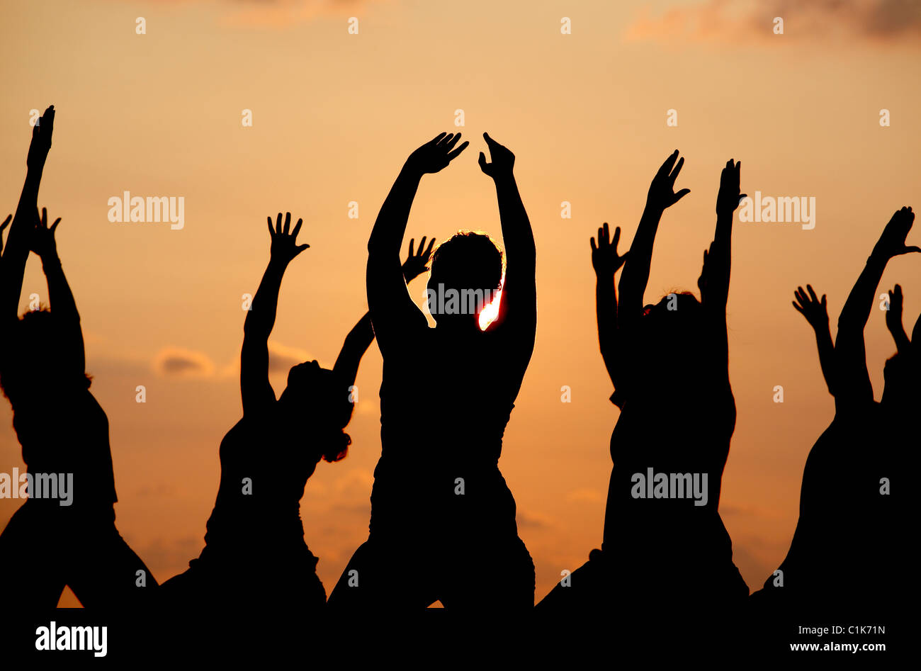 Un gruppo di persone che praticano lo yoga sulla spiaggia al tramonto, Jaco, Costa Rica Foto Stock