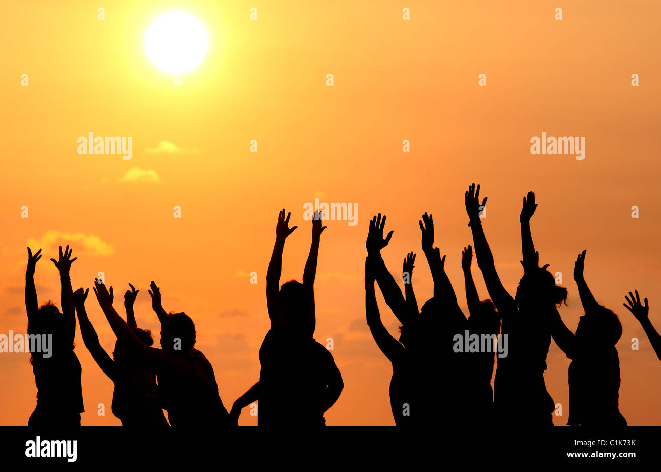 Un gruppo di persone che praticano lo yoga sulla spiaggia al tramonto, Jaco, Costa Rica Foto Stock