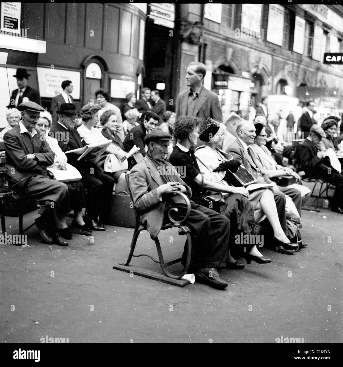 1960s. Londra. Le diverse generazioni di persone sedute sulle panchine a London Victoria Station in attesa per i loro treni. Foto Stock