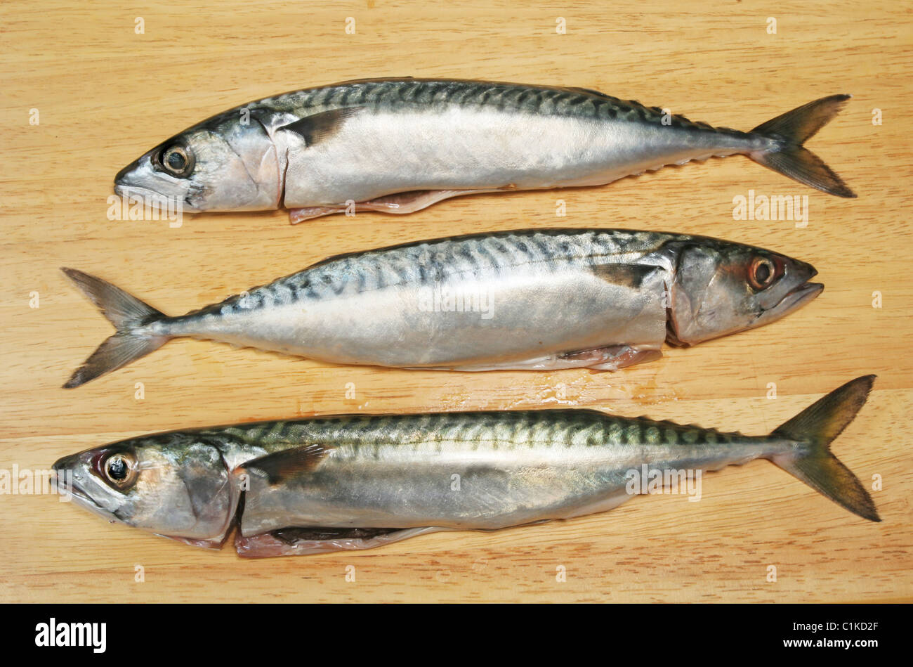Tre sgombro pesce su una tavola di legno Foto Stock