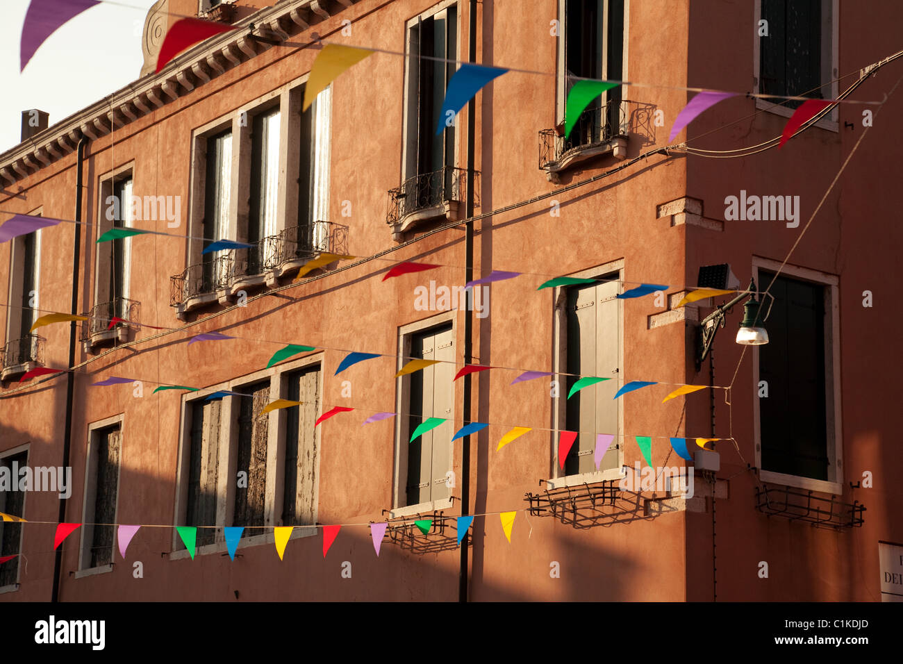 Colorato bunting contro un edificio al tramonto, Venezia, Italia Foto Stock