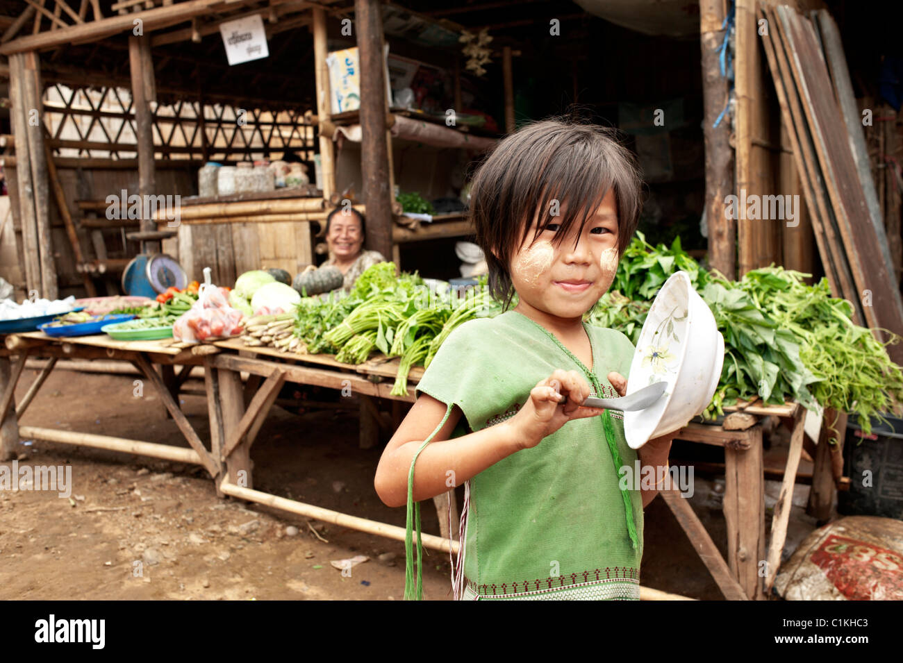 Una giovane ragazza Karn con un cucchiaio e ciotola nel campo per rifugiati di Mae La,, provincia di Tak, Thailandia, in Asia. Foto Stock