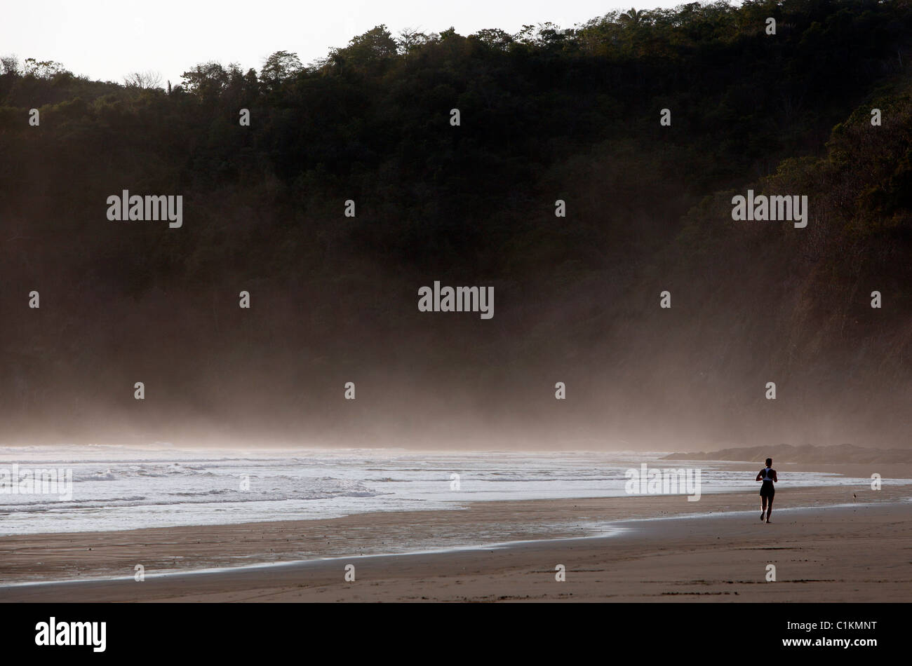 Donna jogging sulla spiaggia Playa San Miguel, Nicoya peninsula, Costa Rica Foto Stock