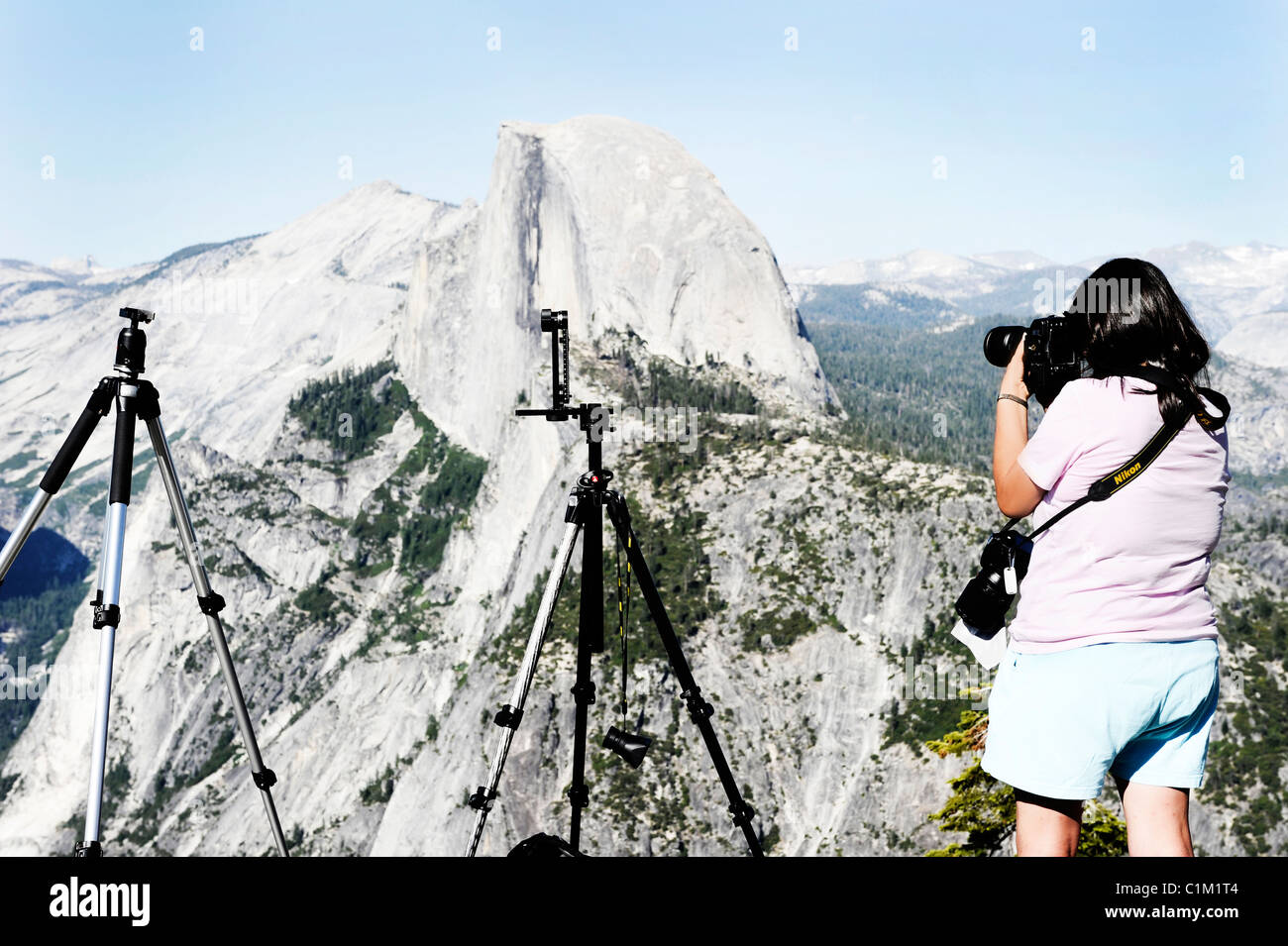 Foto di una donna di scattare le foto di mezza cupola da un punto di vista nella Yosemite National Park, California, Stati Uniti d'America Foto Stock