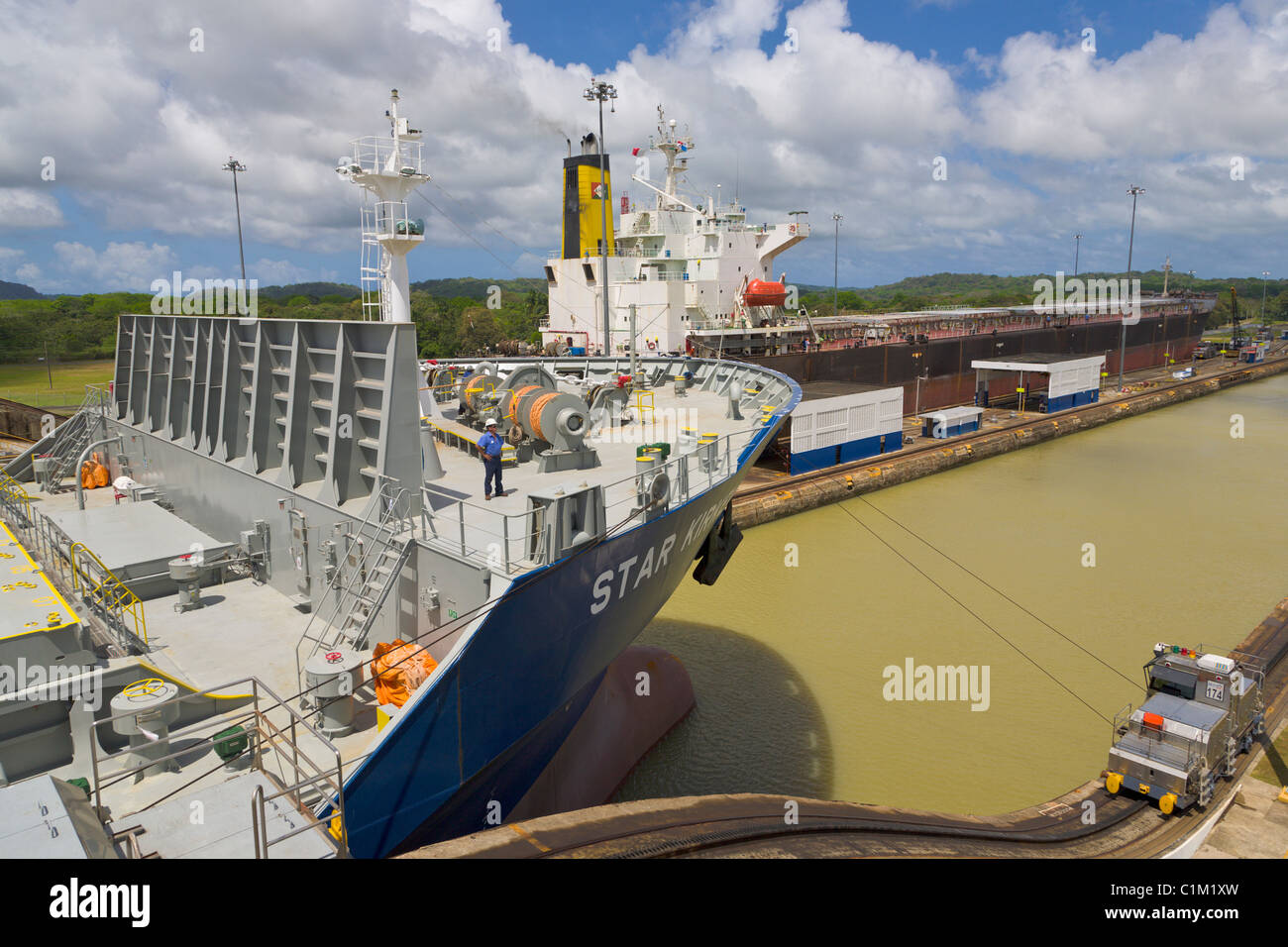 Mulo e norvegese di nave da carico passando attraverso le serrature Gatun, sul Canale di Panama, Panama Foto Stock