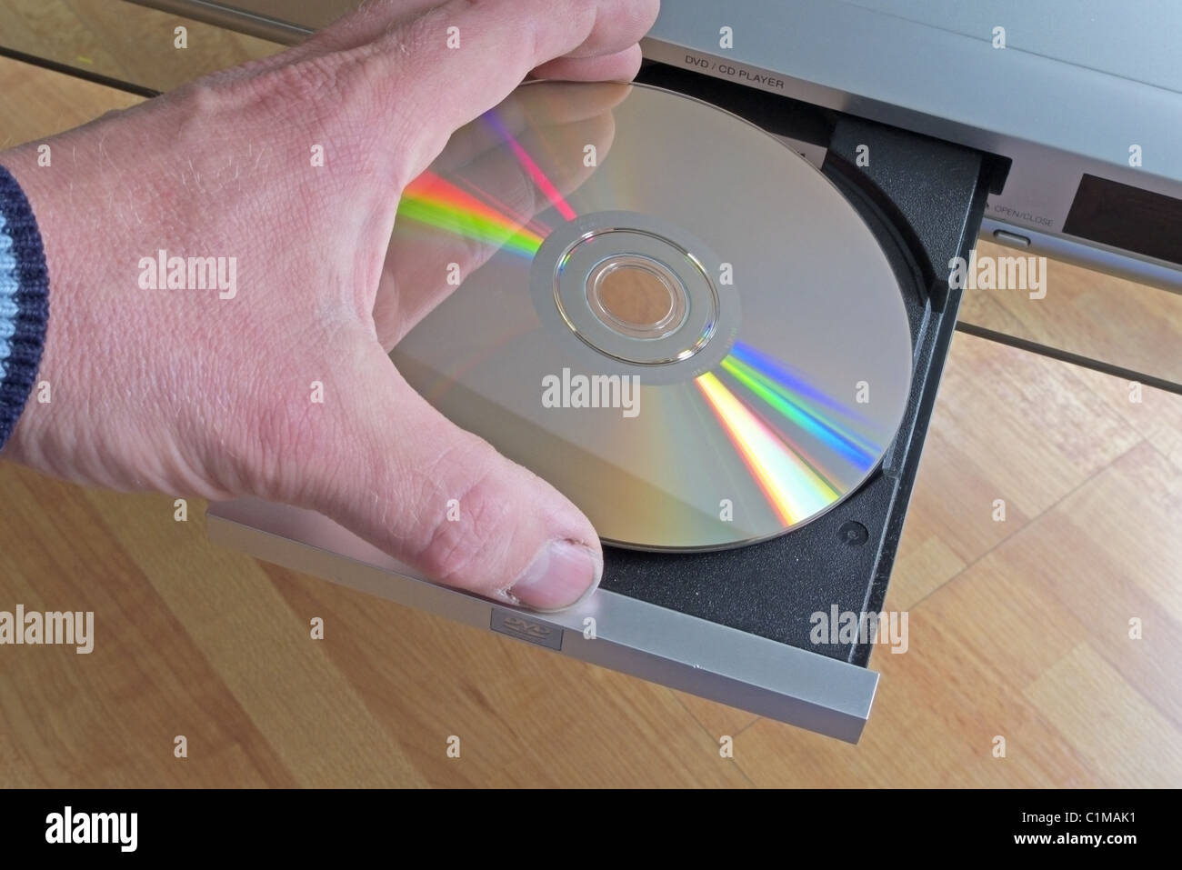 Uomo caucasico collocando un DVD nel cassetto di un lettore DVD modello rilasciato Foto Stock