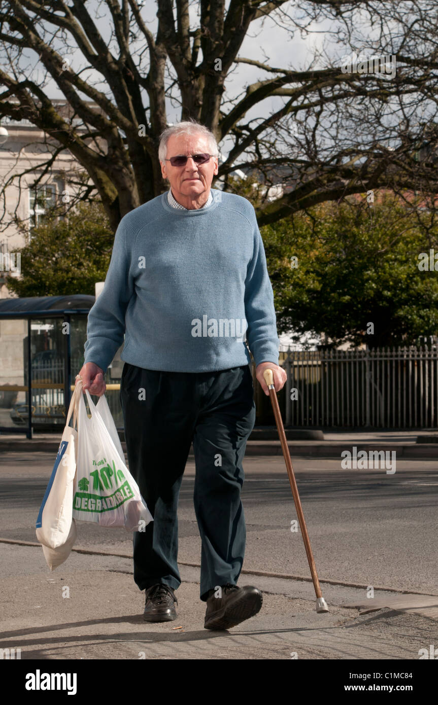 Un pensionato parzialmente disabilitato titolare di pensione o di rendita su un reddito fisso shopping a Aberystwyth. Foto Stock