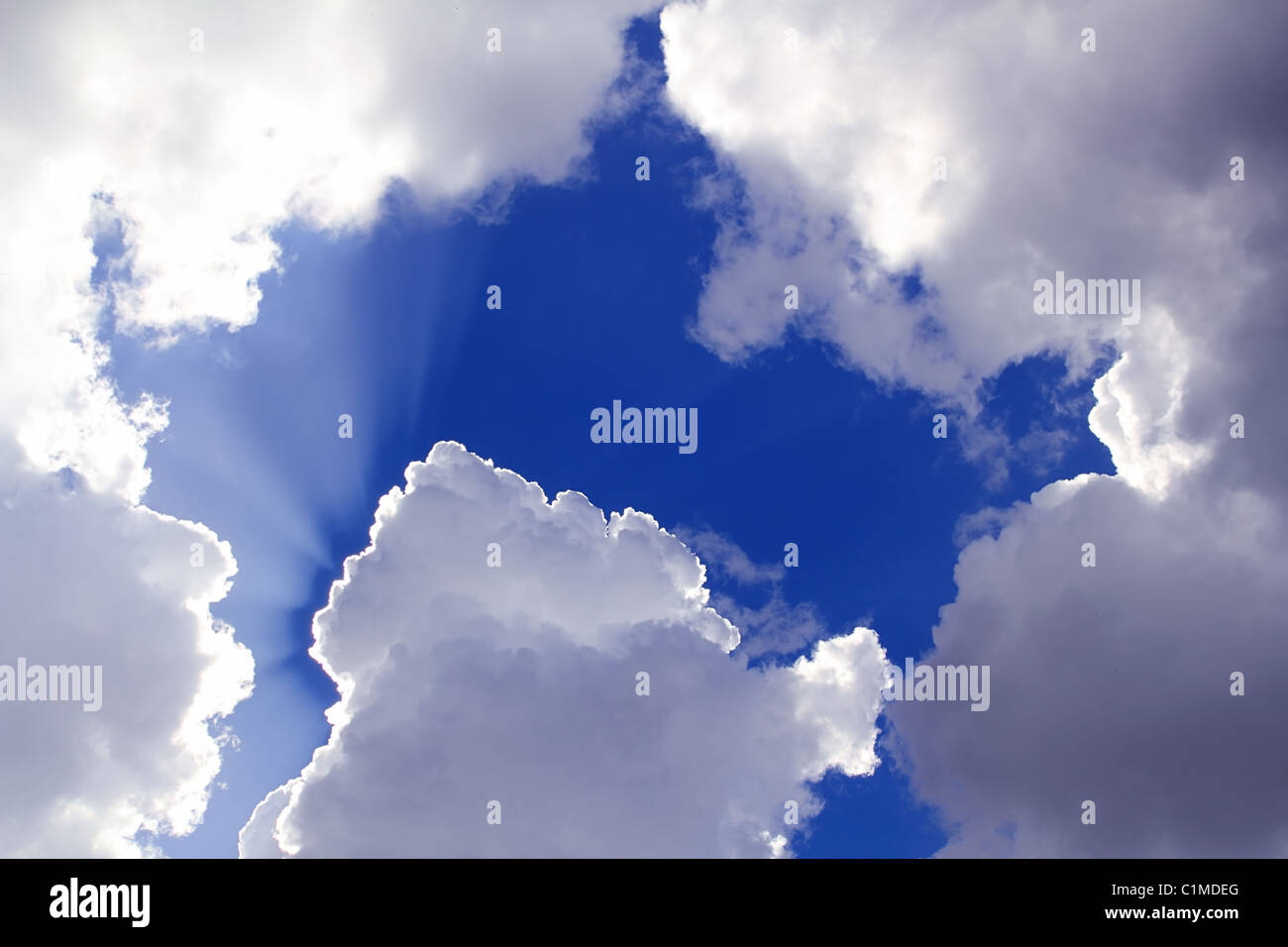 Fasci dal sole nel cielo blu nuvole grigio Sfondo skyscape Foto Stock