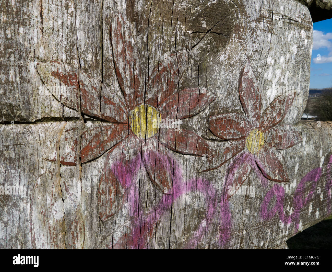 Scultura in legno intagliato con fiore, con graffiti a bordo OLDHAM, LANCASHIRE Foto Stock