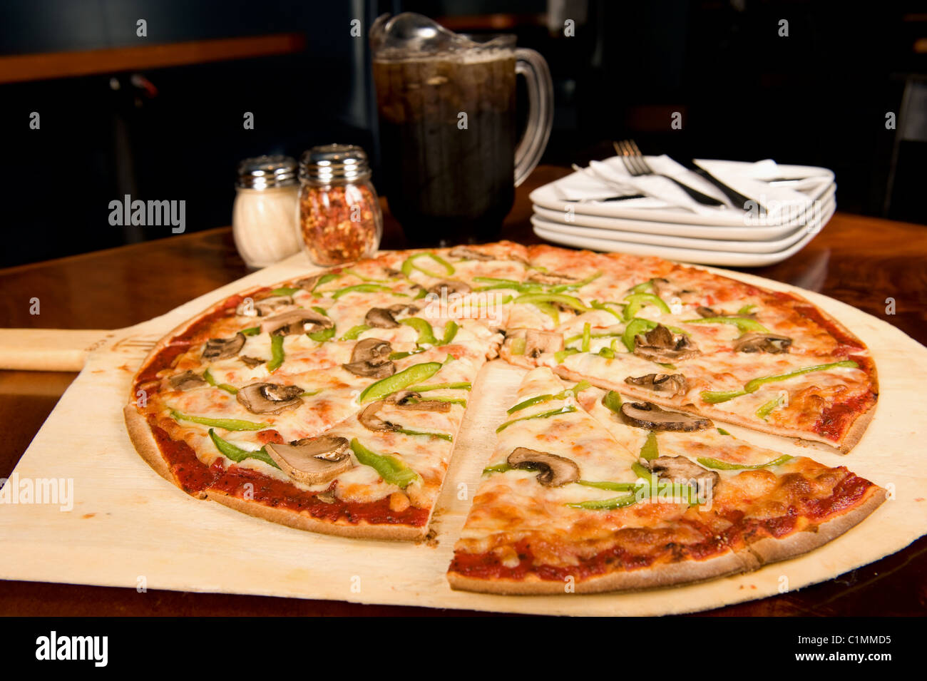 Dimensioni della famiglia pizza e bricco di soda servito presso un ristorante Foto Stock