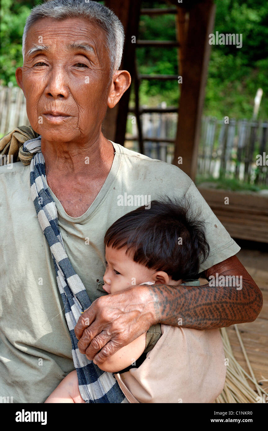 Laos, Oudomxai provincia, Kamu gruppo etnico villaggio nelle vicinanze di Pakbeng, ritratto di un grand-padre con il nipote Foto Stock