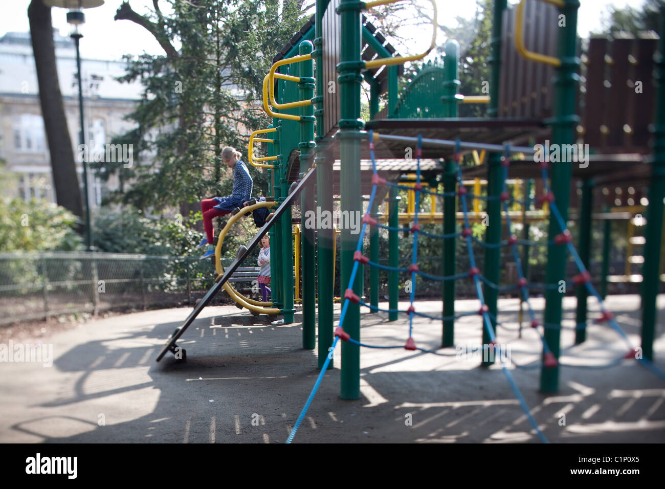 Due ragazze arrampicata su una riproduzione in legno struttura in un parco in Francia Foto Stock