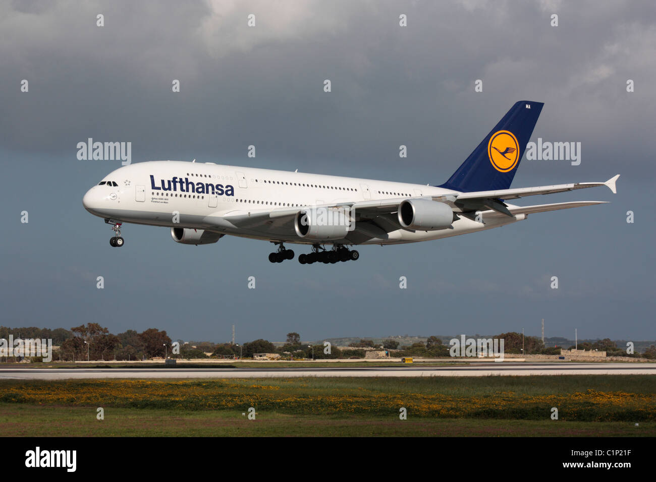 Commerciale viaggi dell'aria. Lufthansa Airbus A380 widebody grande aereo di linea in arrivo a Malta. Vista laterale che mostra il doppio ponte progettazione di questo aeromobile. Foto Stock