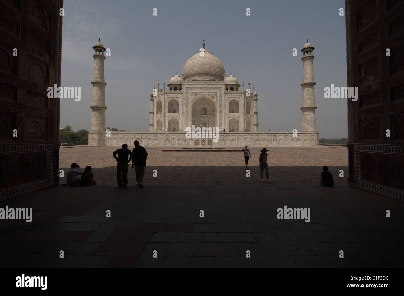 Il turista a godere la vista del Taj Mahal, India. I turisti il resto in ombra Foto Stock