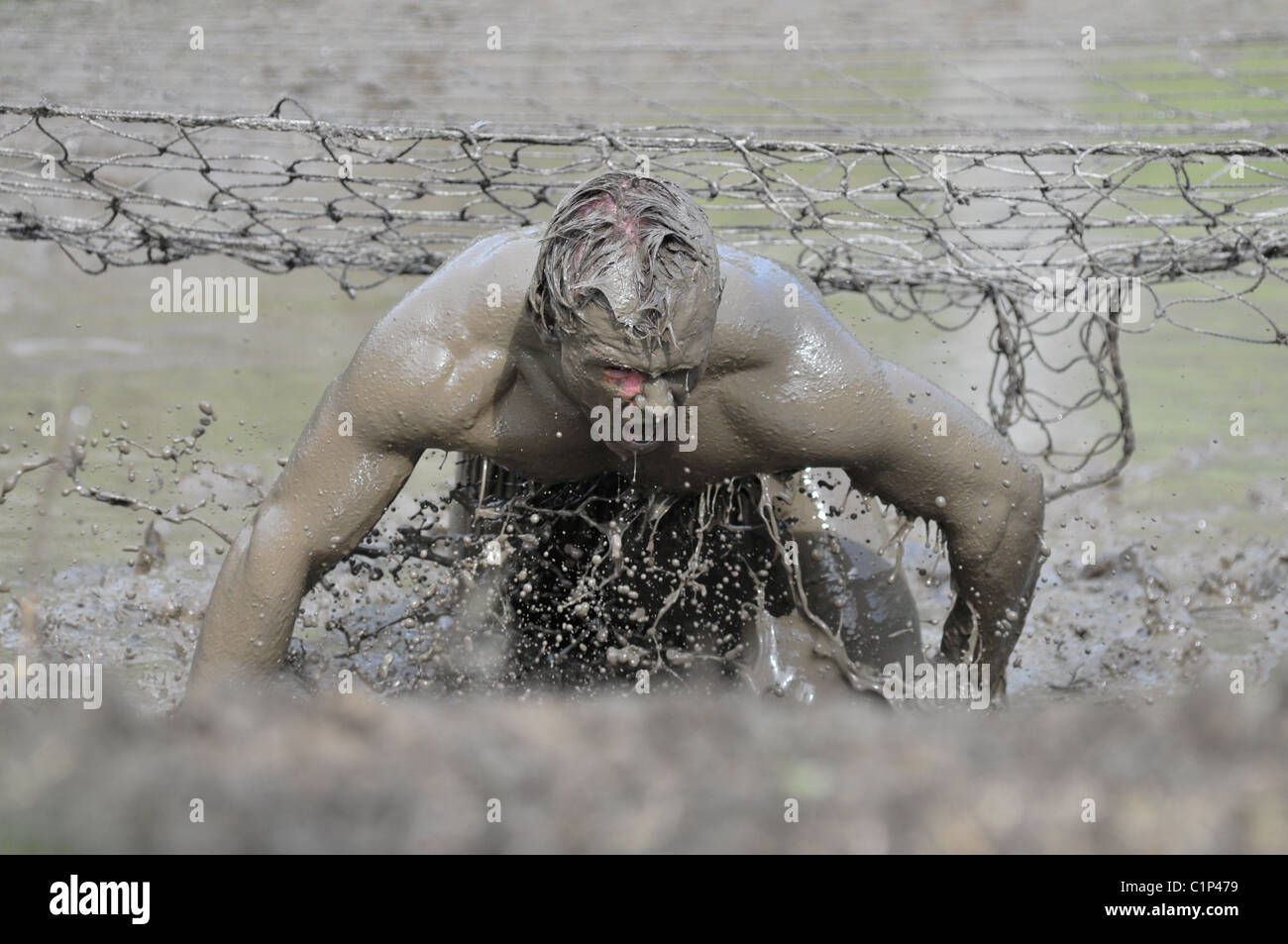 I concorrenti splash attraverso il pozzo del fango al 2010 Phitathalon in Marysville, Ohio Foto Stock
