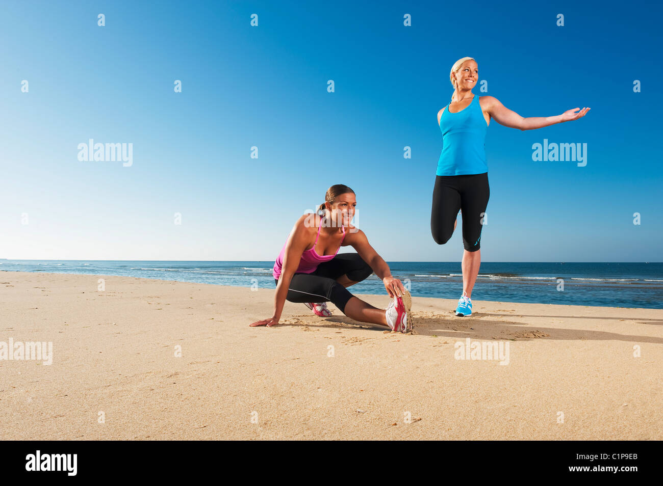 Due delle donne che esercitano sulla spiaggia Foto Stock