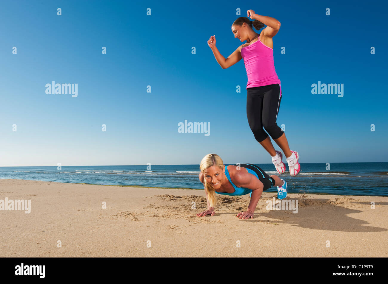Due delle donne che esercitano sulla spiaggia Foto Stock