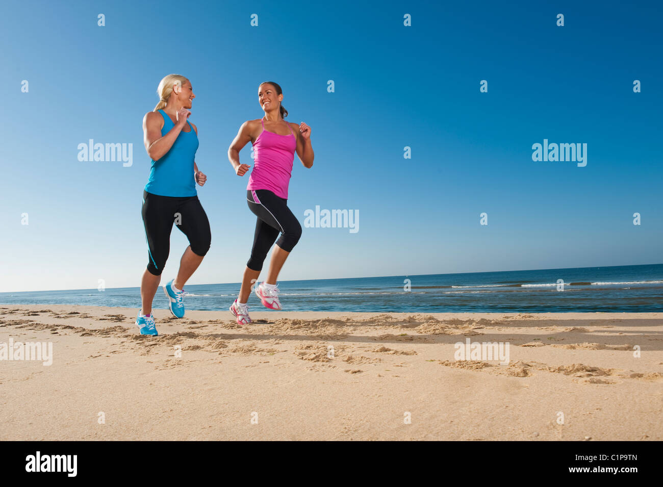 Due donne jogging sulla spiaggia Foto Stock