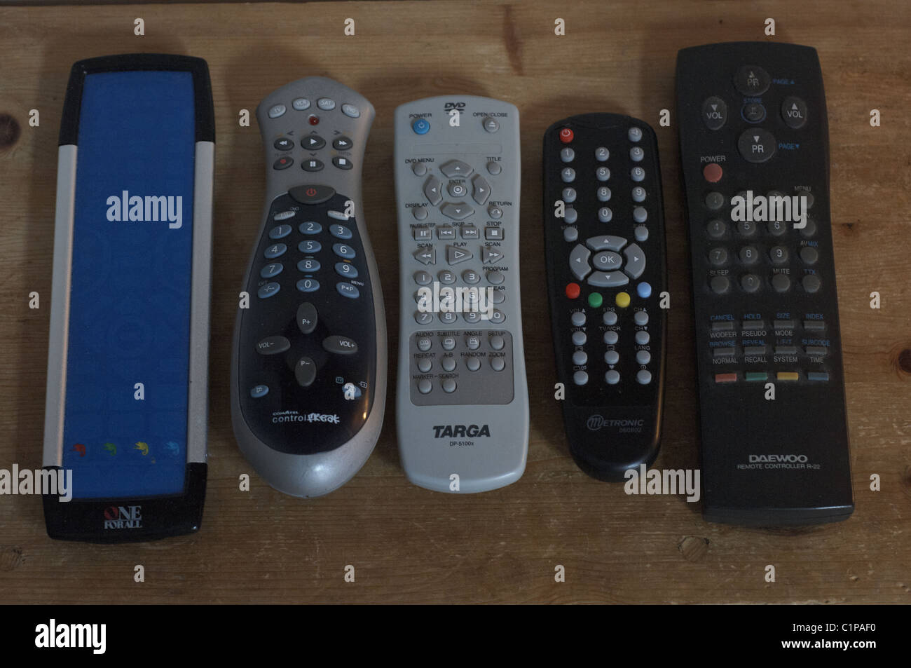 I comandi remoti line up su un ripiano in legno Foto Stock