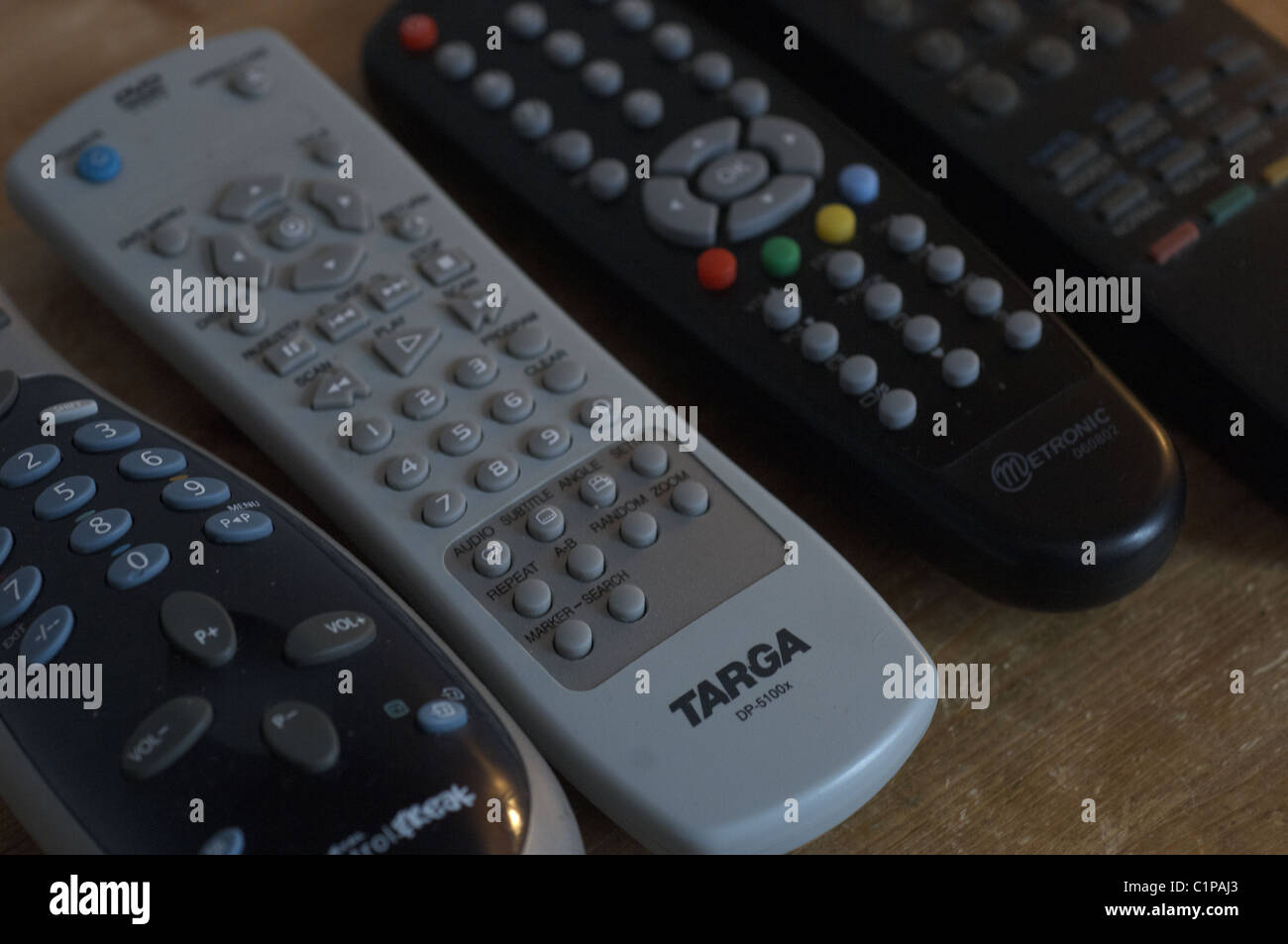 I comandi remoti line up su un ripiano in legno Foto Stock