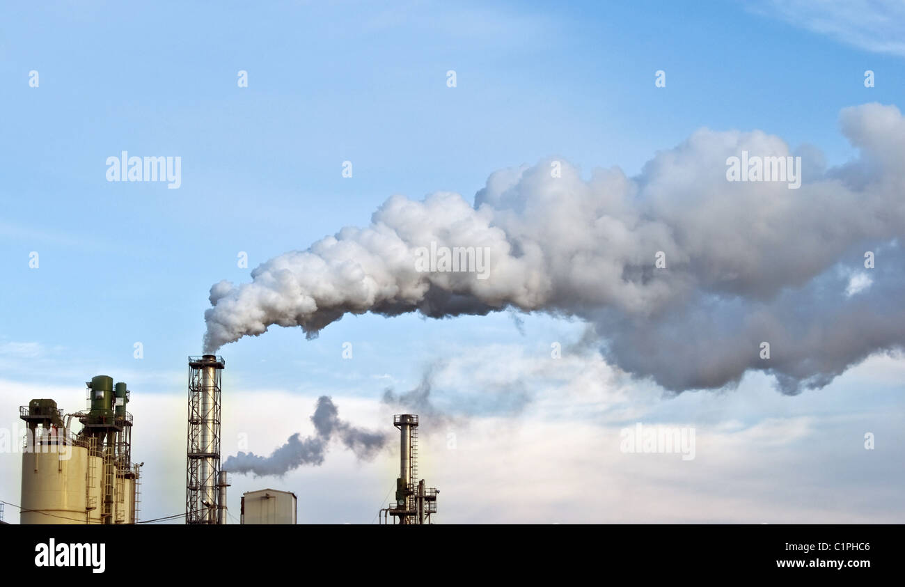 Il fumo della fabbrica, inquinando l'aria con il cielo nuvoloso Foto Stock