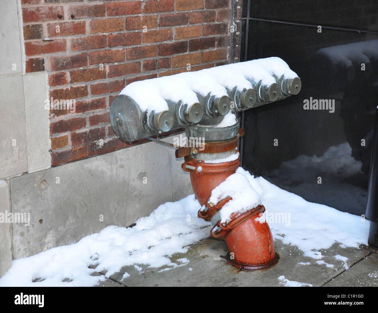 Idrante di fuoco con uscite multiple ricoperta di neve Foto Stock