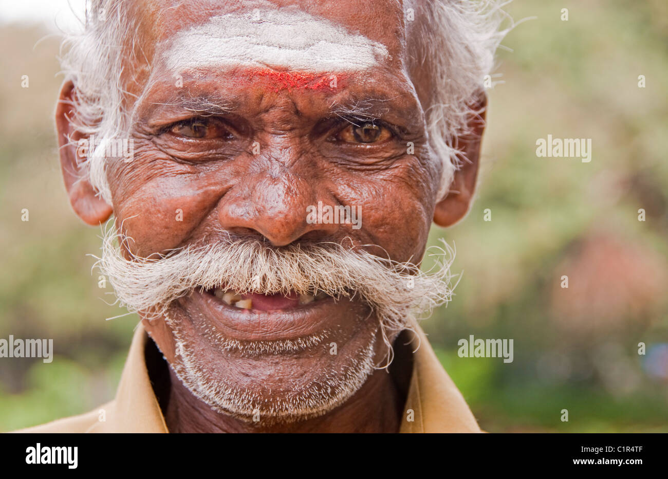 Anziani uomo indù tuk tuk driver su strade di Madurai Foto Stock