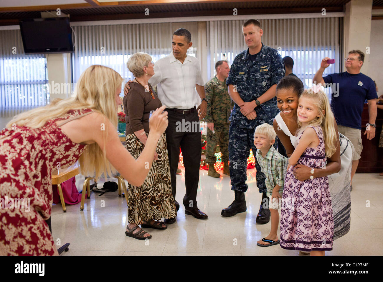 Il presidente Barack Obama e la First Lady Michelle Obama greet service uomini e donne e le loro famiglie, durante la cena di Natale. Foto Stock