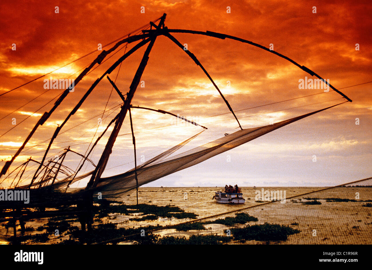 Cinese a sbalzo di reti da pesca al tramonto lungo la punta di Fort Cochin sulla costa a Cochin (Kochi) Foto Stock
