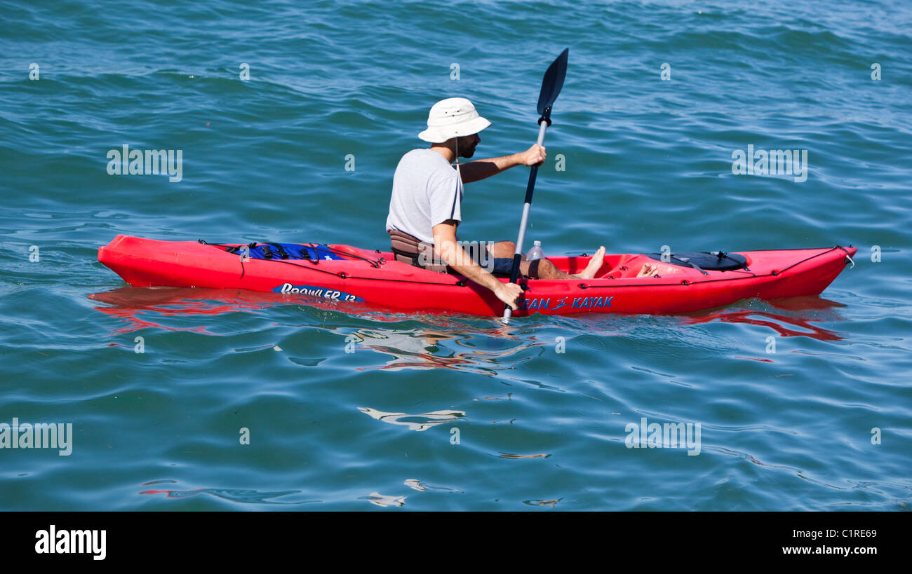 Un canottaggio maschile in kayak nel mare, Miami, Florida, Stati Uniti. Foto Stock