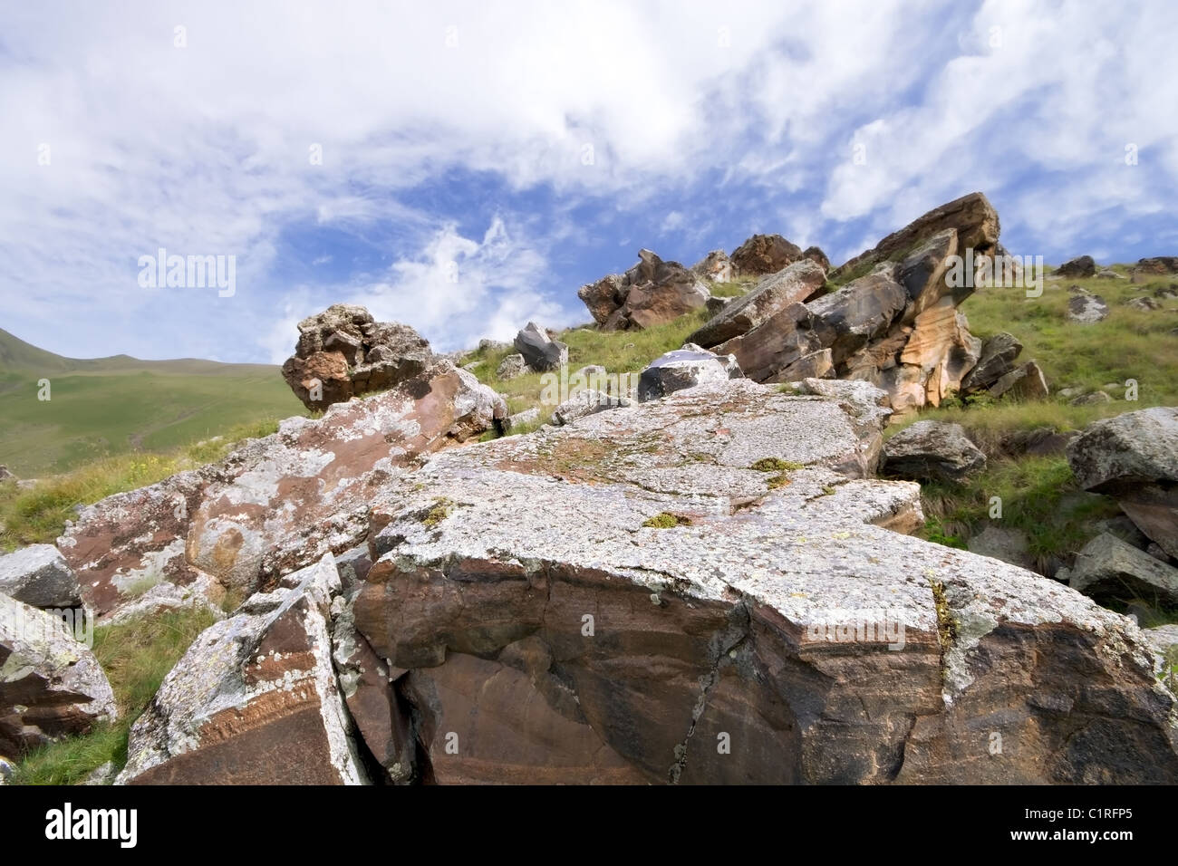 Cumulo di rocce e massi in valle di montagne del Caucaso. Il cielo blu con nuvole. Kabardino-Balkaria. La Russia. Foto Stock