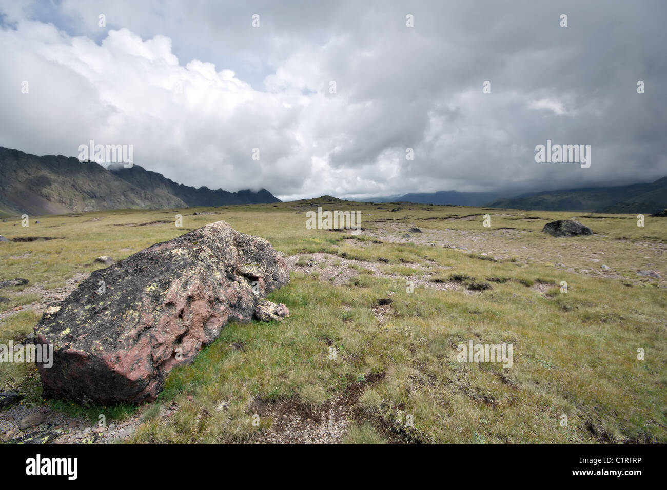 Highland pascolo (Prato) con pietre contro la nebbia di nuvole. Montagne del Caucaso. Kabardino-Balkaria. La Russia. Foto Stock